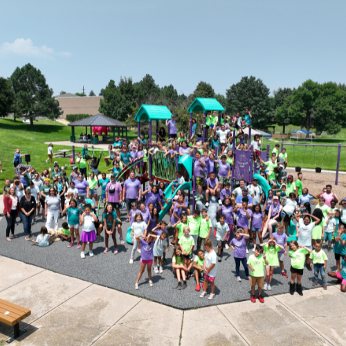 Group of summer camp participants take a photo at a park together.