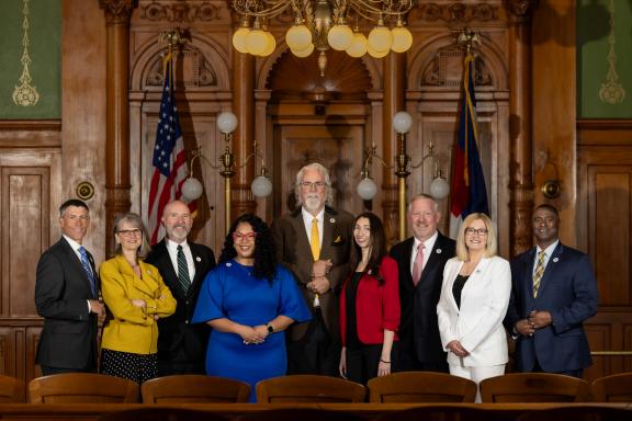 2025 group shot of City Council in the Council Chambers. From left to right: Brian Risley, President Pro Tem (At Large), Nancy Henjum (District 5), Dave Donelson (District 1), Kimberly Gold (District 4), David Leinweber (At Large), Brandy Williams (District 3), Tom Bailey (District 2), Lynette Crow-Iverson, President (At Large), Roland Rainey (District 6)