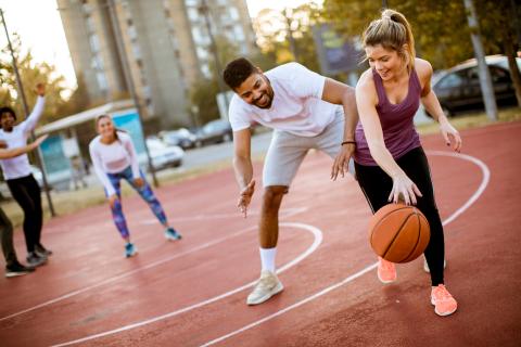 Stock image of a man and a woman playing basketball together