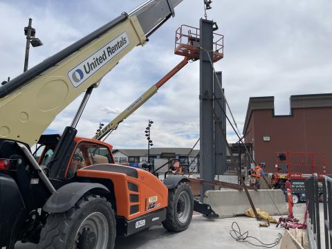 Construction on the sound walls at Ford Amphitheater begins, with a crane helping to place a steel beam.