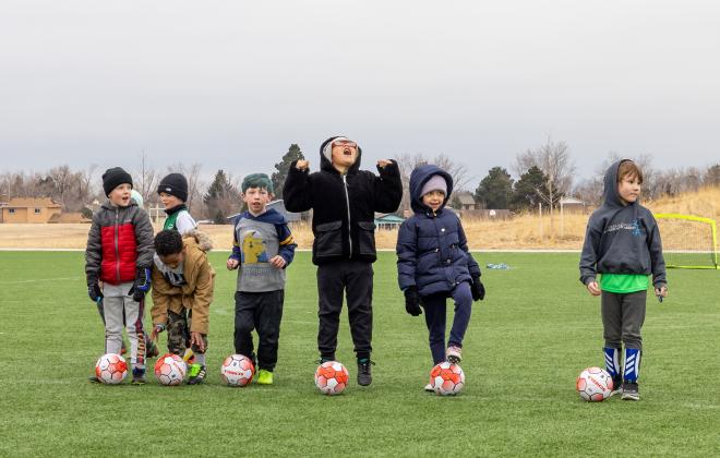 Children gather and play with their new soccer balls donated by Scheels and the Colorado Springs Police Department